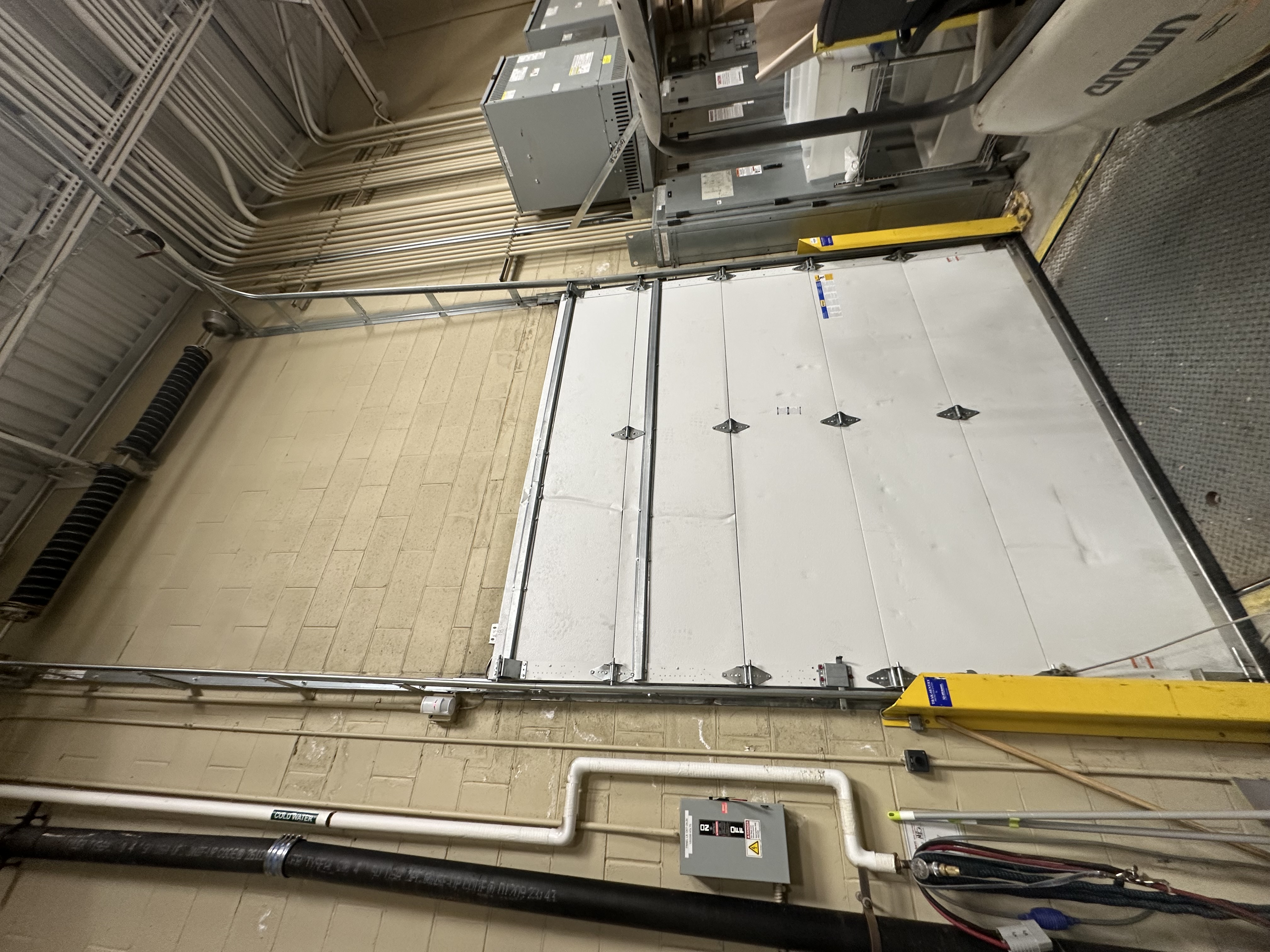 Large commercial overhead garage door with heavy-duty track system and industrial motor units